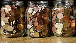 Três vidros cheio de moedas, indicando que a pessoa esta juntando dinheiro para o futuro