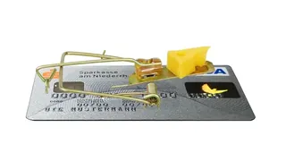 Uma amadilha em forma de uma ratoeira em cima de um cartão de credito